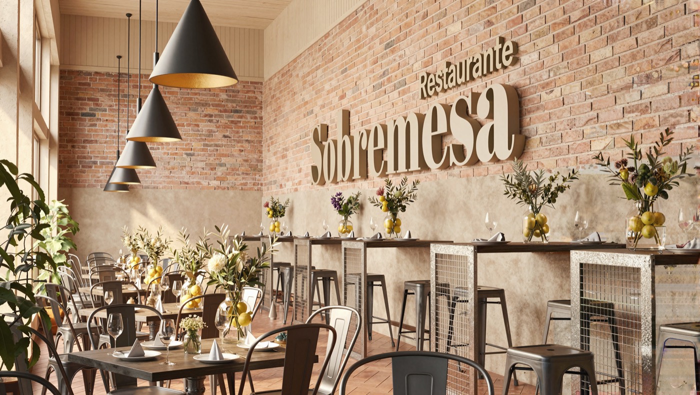 Sala del restaurante Sobremesa, con mesas de madera, lámparas negras y el rótulo en la pared de ladrillo